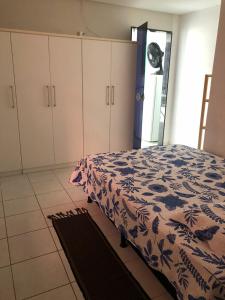 a bedroom with a bed and white cabinets at Apartment Pé na Areia - Guarapari in Guarapari