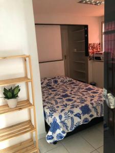 a bedroom with a bed with a blue and white pattern at Apartment Pé na Areia - Guarapari in Guarapari