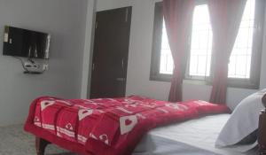 乌提Kitty cottage的卧室配有红色毯子,位于床上