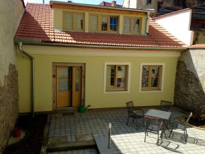 una pequeña casa amarilla con mesa y sillas en Apartman U Hippolyta en Jindrichuv Hradec