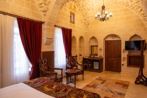 Kasr-i Divan Hotel في ماردين: غرفة نوم بسرير وثريا