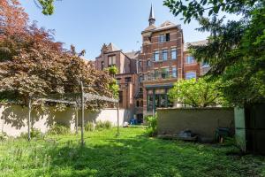 a yard in front of a brick building at B&B Baron Osy Suite Four Garden in Antwerp