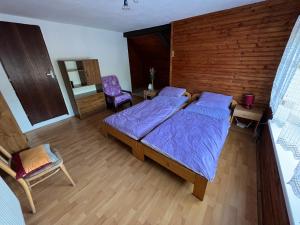 Un dormitorio con dos camas y una pared de madera. en Ubytovanie na súkromí, en Otilia