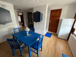 una mesa azul y sillas en una cocina con nevera en Ubytovanie na súkromí, en Otilia
