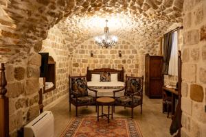 Kasr-i Divan Hotel في ماردين: غرفة نوم بها سرير وطاولة وكراسي