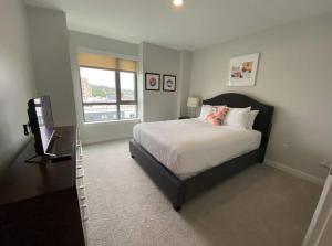 a bedroom with a bed and a television in it at Spacious Apt Downtown in Quincy