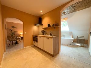 a kitchen with a tub and a sink and a bathroom at Voyage à Bali in Sarreguemines