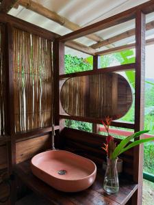 bagno con lavandino rosa e finestra di La Mona Eco Cabins a Palomino