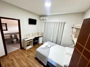 a hospital room with a bed and a mirror at Pousada Recanto das Cores in Penha
