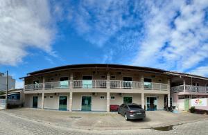a building with a car parked in front of it at Pousada Recanto das Cores in Penha