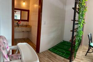 a bathroom with a green floor in a room at Pousada Recanto das Cores in Penha