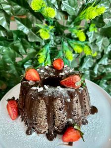 a piece of chocolate cake with strawberries on a plate at Pousada Recanto das Cores in Penha +61 photos
