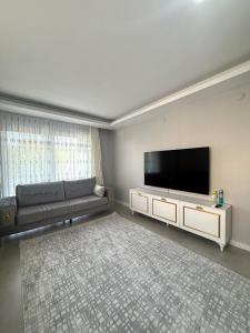 a living room with a couch and a flat screen tv at Luxury Villa with Pool Near Sarimsakli Beach in Ayvalık