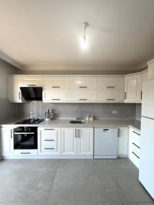 a white kitchen with white cabinets and a sink at Luxury Villa with Pool Near Sarimsakli Beach in Ayvalık