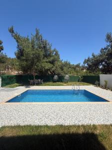 a swimming pool in the middle of a yard at Luxury Villa with Pool Near Sarimsakli Beach in Ayvalık