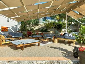 a patio with couches and chairs under a wooden umbrella at Agava Apartments in Sutivan