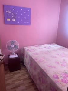 Dormitorio rosa con cama y ventilador en Casa familiar perto da Escola São Cristovão, en Garanhuns