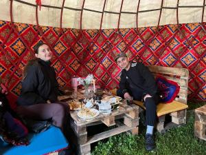 two people sitting at a table in a yurt at Aalam yurt camp Altyn-Arashan in Mineralʼnyy Istochnik Altyn-Arasan