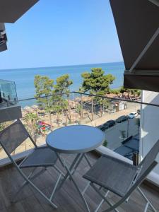 シェンジンにあるDolce Mare Apartmentの海が見えるバルコニーに置かれたテーブルと椅子