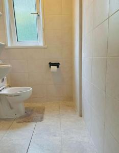 a bathroom with a toilet and a window at Private Room in Glasgow City in Hillfoot