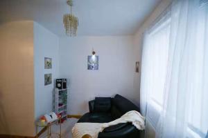 a living room with a black chair and a window at Wythenshawe Greenbrow Retreat in Manchester