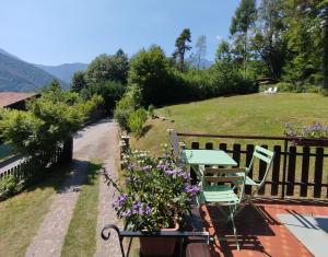 a patio with a table and chairs and flowers at Villa Carla - Bosco in Ledro