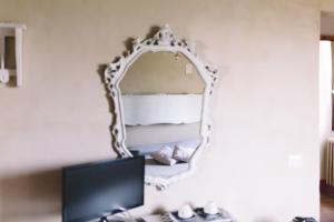 a mirror on a wall above a desk with a tv at Tenuta di Vico Moricino in Anagni