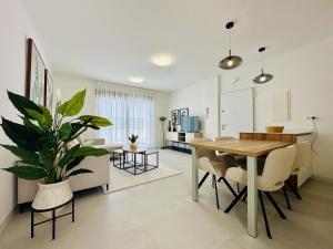 a dining room and living room with a table and a plant at El Alba in Torre-Pacheco