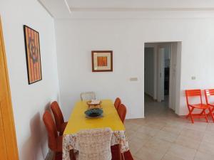 a dining room with a yellow table and chairs at Charming 2 bedrooms Appartment in Agadir nʼ Aït Sa