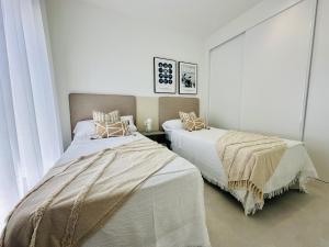 two beds in a room with white walls at El Alba in Torre-Pacheco +8 photos