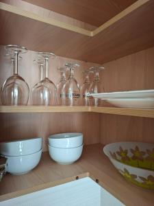 a kitchen shelf with bowls and glass bottles on it at Casa Beby in Candelaria +20 photos
