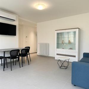 a living room with a table and chairs and a couch at Modern apartment with parking in Lignano Sabbiadoro