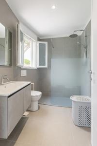 a bathroom with a sink and a toilet and a shower at Modern apartment with parking in Lignano Sabbiadoro