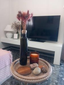 a vase with flowers and a candle on a table at Elmar Mosaic Suites in Paralion astros