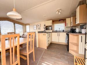 a kitchen and dining room with a table and chairs at Sanderling, 289 Ynyslas Beach, Borth in Borth