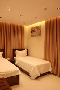 a hotel room with two beds and curtains at سما المملكة للشقق المخدومة ـ غبيرا - اقتصادي in Riyadh