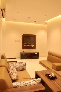 a living room with a couch and a flat screen tv at سما المملكة للشقق المخدومة ـ غبيرا - اقتصادي in Riyadh