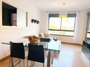 a living room with a glass table and a couch at Elegante apartamento con piscina A un paso de Sevilla San Miguel in Camas