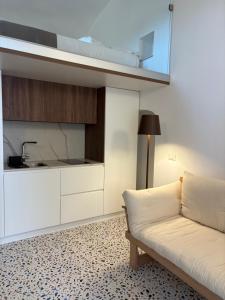a living room with a couch and a kitchen at Guest House Signature in Bacoli