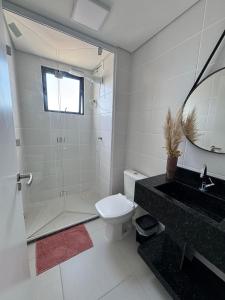 une salle de bains avec douche, toilettes et lavabo dans l'établissement Apto Vista Mar | 200m Praia | 7 minutos do Parque, à Penha