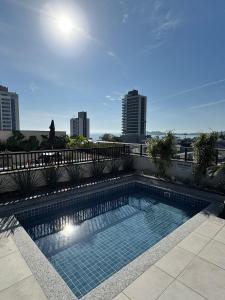 une piscine sur le toit d'un immeuble dans l'établissement Apto Vista Mar | 200m Praia | 7 minutos do Parque, à Penha