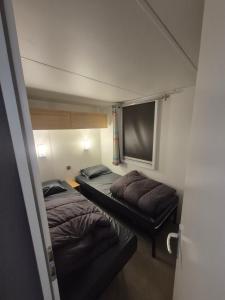 a small room with two beds and a flat screen tv at Mobil-home camping 5 etoiles in Valras-Plage