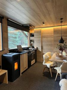 une cuisine avec une cuisinière et une table avec des chaises dans l'établissement refugio en el bosque, à La Molina