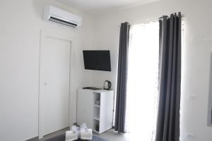 a white room with a television and a window at Royal View Apartment in Caserta