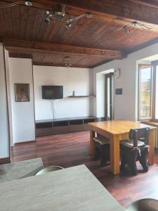 a large room with a wooden table and a flat screen tv at Casa Fernanda in Omegna