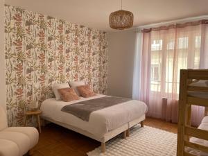 a bedroom with a bed with a floral wallpaper at Le Refuge de l'hyper centre de Compiègne in Compiègne