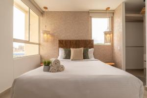 a large white bed in a room with windows at Apartment with a Pool and Parking 2Bed in Cartagen in Cartagena de Indias +25 photos