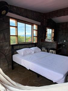 Un dormitorio con una cama en una habitación con ventanas. en Hidden Gem in the desert, en Aipe
