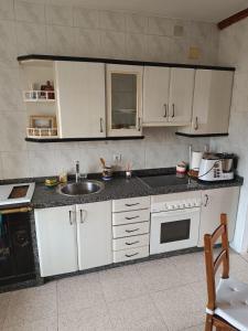 a kitchen with white cabinets and a sink at Casa Esther and Pepe VUT LE884 in Riego de la Vega