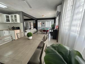 a kitchen and dining room with a wooden table and chairs at Big House Next to the Airport in San Juan